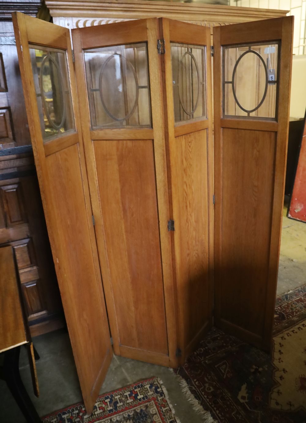 An Edwardian glazed oak four fold dressing screen, each panel 40 x 180cm